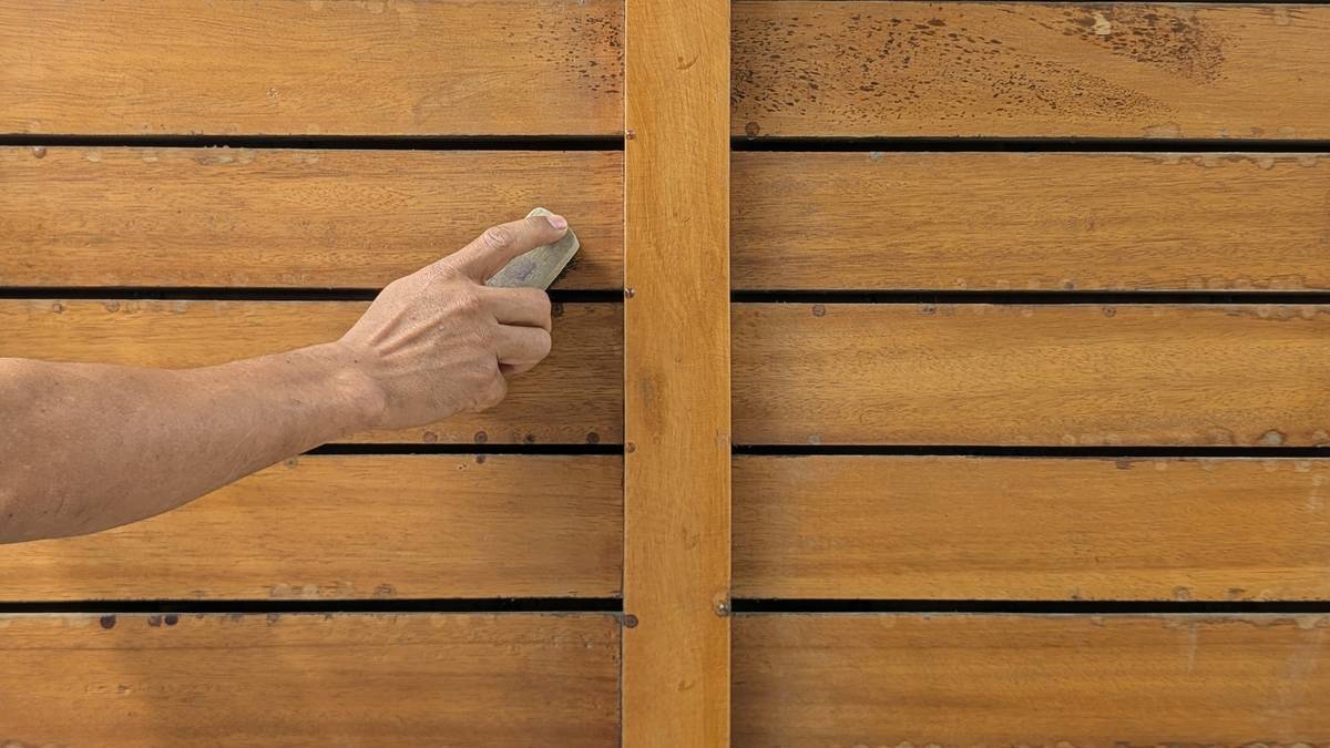 diy project beginner woodworking how to: close-up of a beginner's hands measuring a pine board with a tape measure, safety glasses nearby, and a labeled beginner-friendly project list on notebook paper